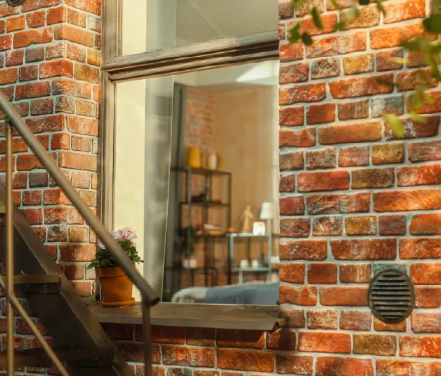 The facade of a brick building with a visible windowpane.